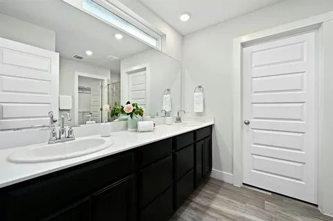 a bathroom with a double vanity sink a mirror and a bathtub