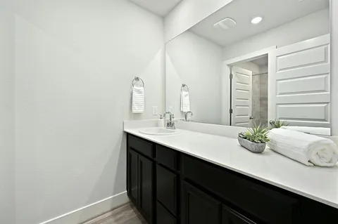 a bathroom with a double vanity sink and large mirror