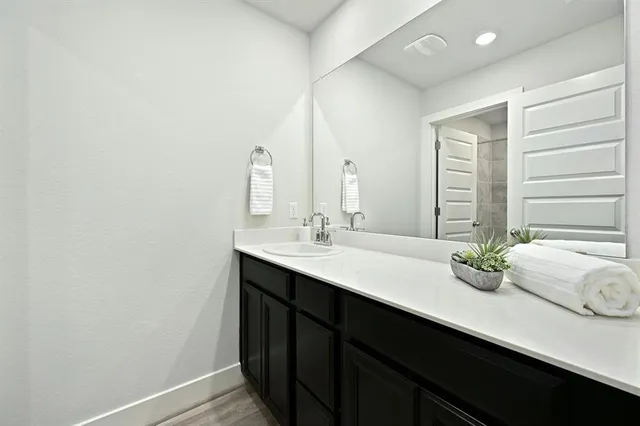 a bathroom with a double vanity sink and large mirror