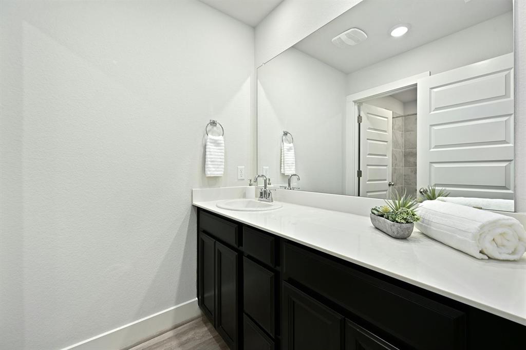 7318 Harmony Shoals Bend, Unit 182 Austin, TX 78744 - Photo 22 of 27 a bathroom with a double vanity sink and large mirror