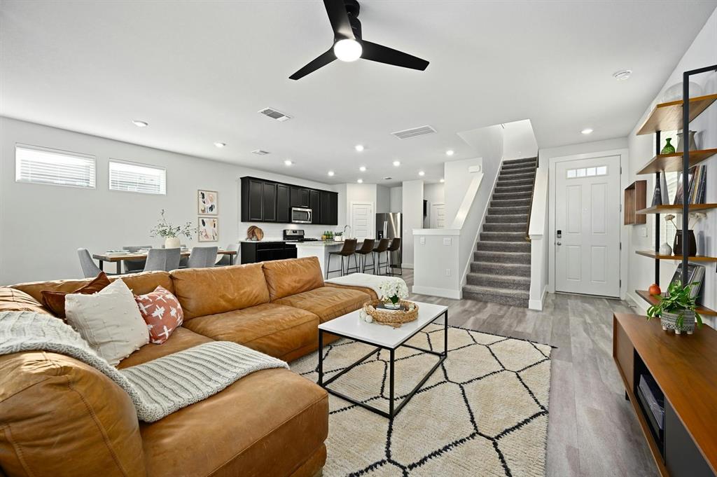 7318 Harmony Shoals Bend, Unit 182 Austin, TX 78744 - Photo 3 of 27 a living room with furniture and wooden floor