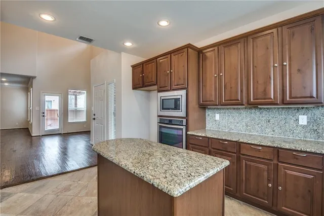 a kitchen with stainless steel appliances granite countertop wooden cabinets a granite counter tops and a sink