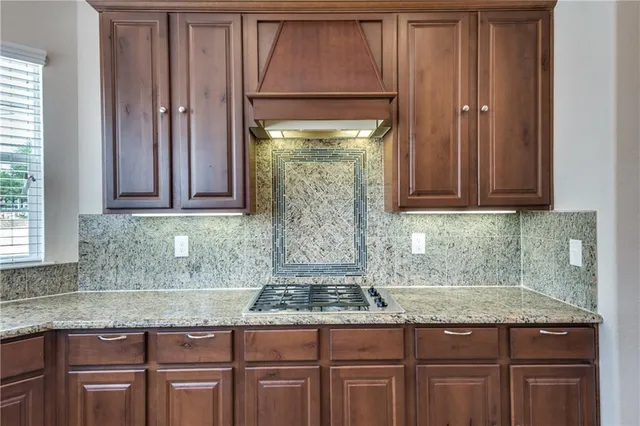 a kitchen with granite countertop a sink stove and cabinets