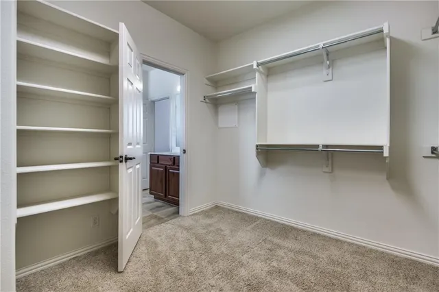 a view of walk in closet with empty racks