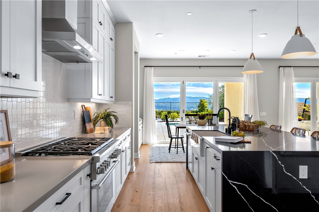 28414 Old Spgs Road Castaic, CA 91384 - Photo 14 of 62 a kitchen with lots of counter top space a stove a dining table and chairs