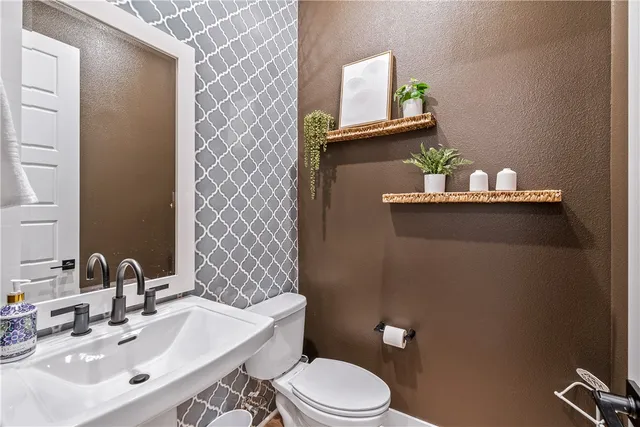 a bedroom with a bed a chandelier and a flat tv screen
