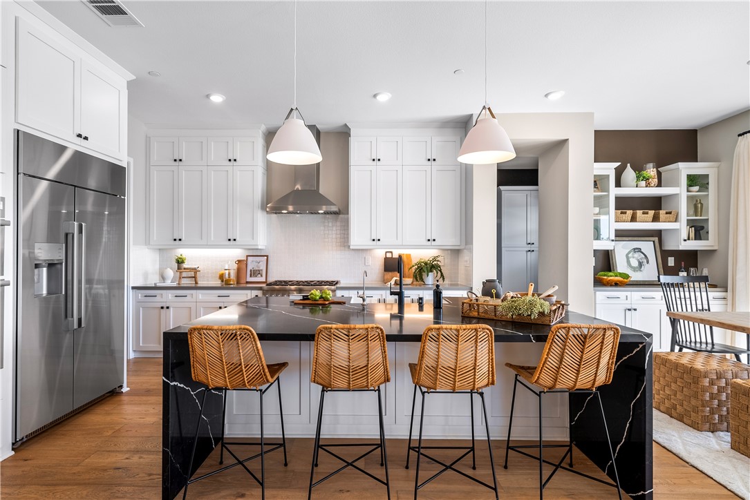28414 Old Spgs Road Castaic, CA 91384 - Photo 9 of 62 a kitchen with stainless steel appliances kitchen island granite countertop a dining table chairs and a refrigerator
