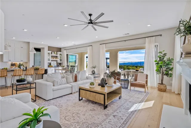 a open kitchen with stainless steel appliances granite countertop a stove a sink dishwasher and a dining table with wooden floor