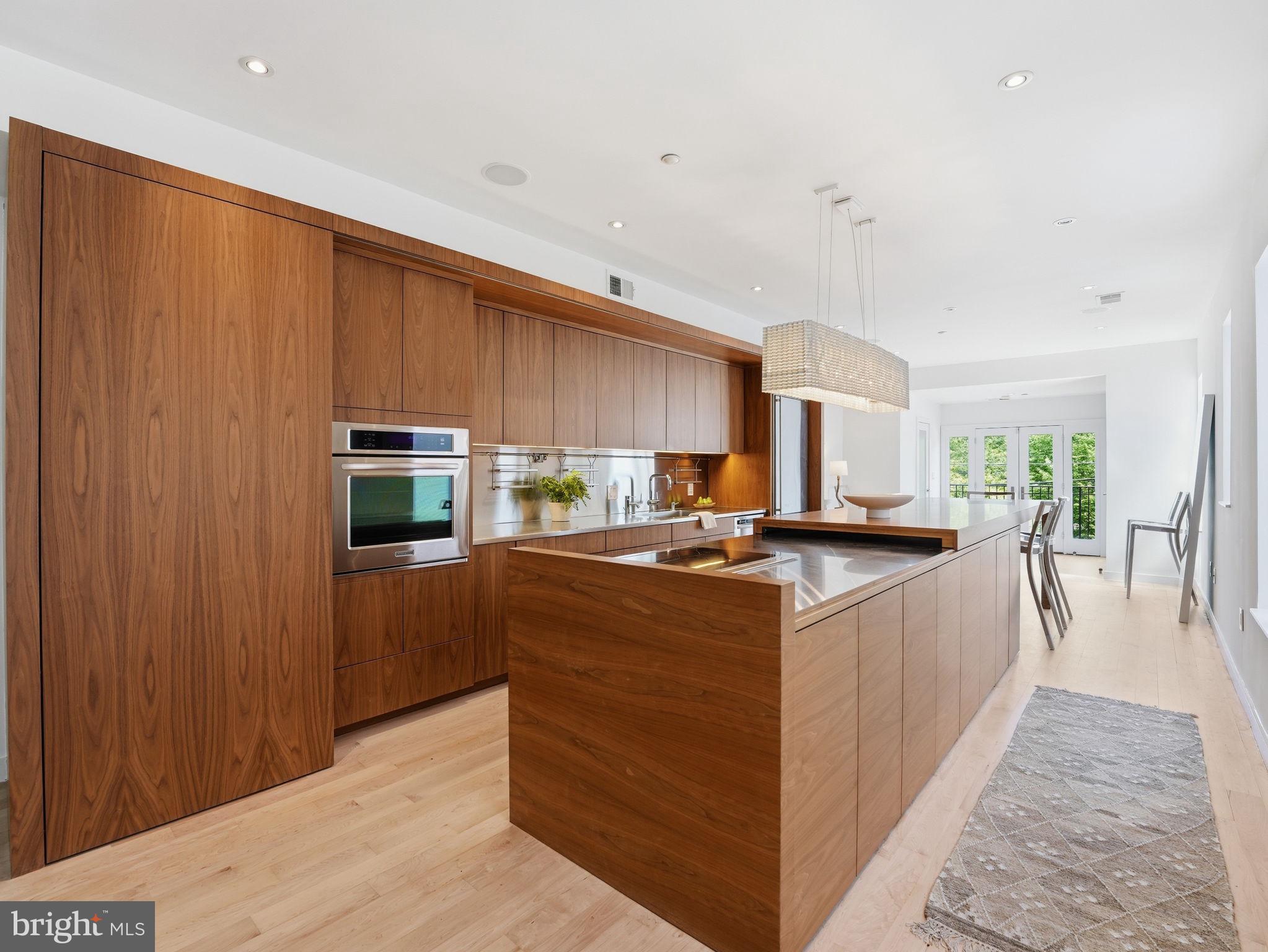1845 Calvert Street Northwest Washington, DC 20009 - Photo 13 of 48 a kitchen with stainless steel appliances granite countertop a stove top oven a refrigerator a sink and dishwasher with wooden floor