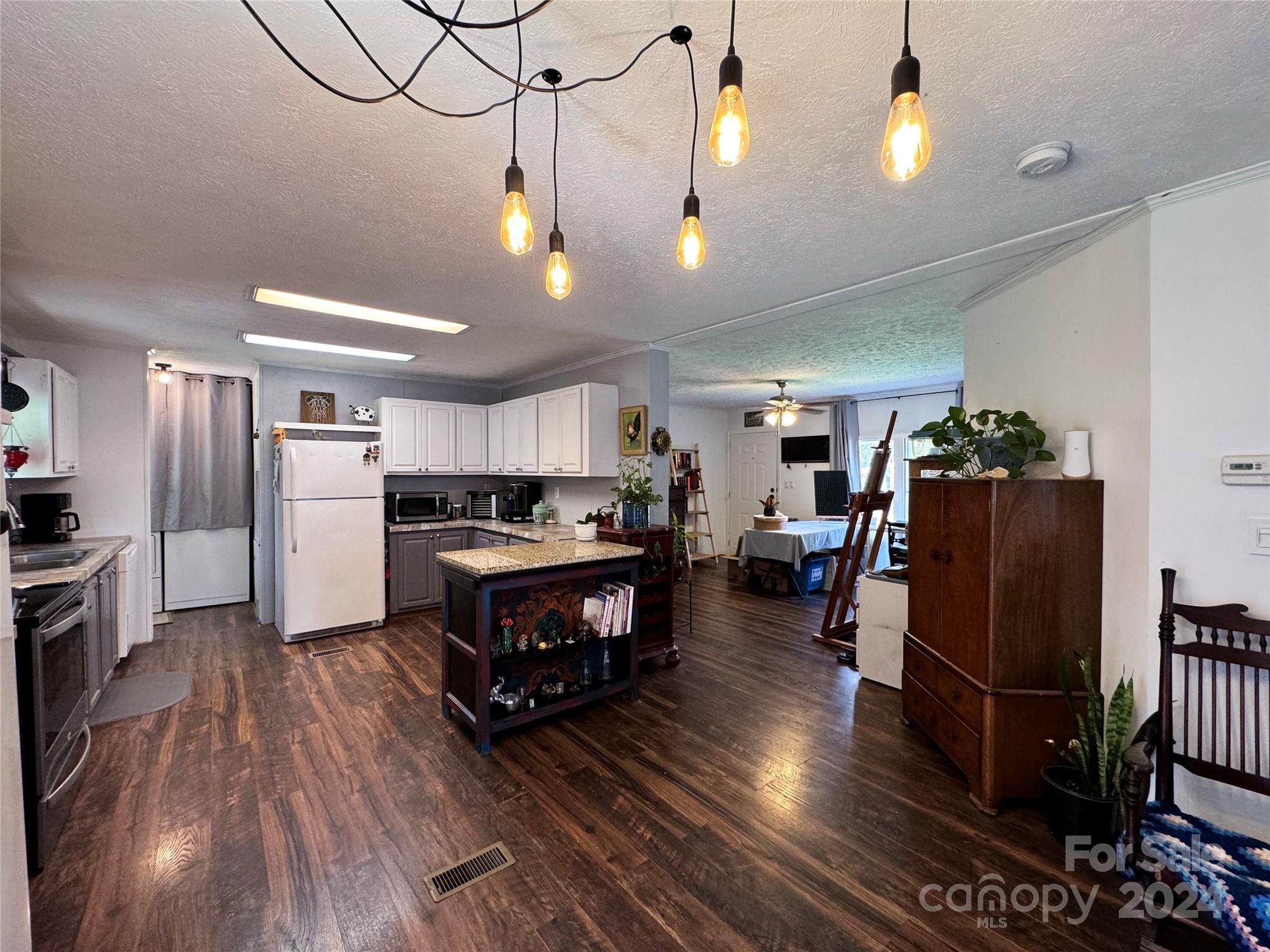790 Langley Road Lancaster, SC 29720 - Photo 7 of 36 a kitchen with stainless steel appliances granite countertop a refrigerator dining table and chairs with wooden floor