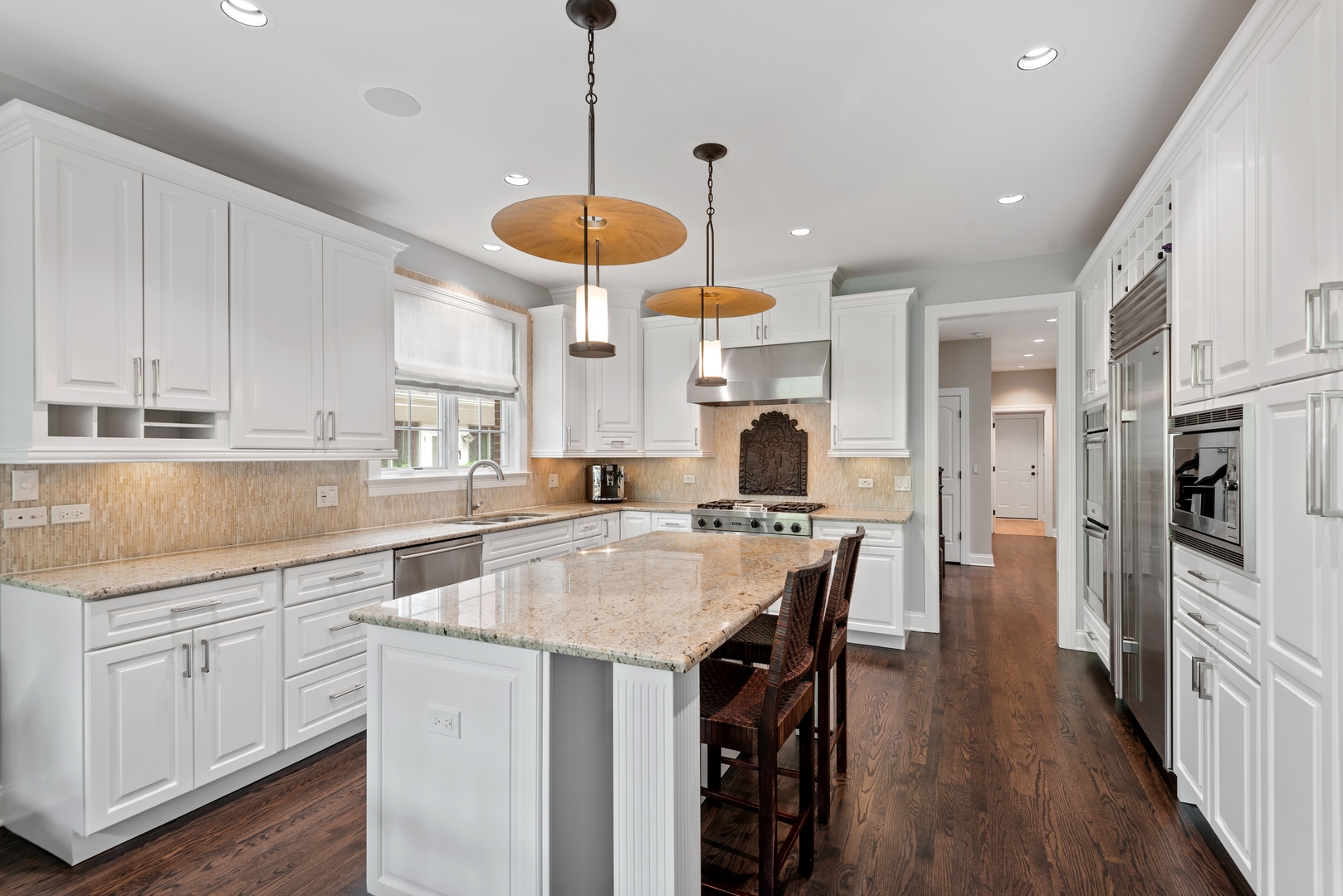700 Harvard Street Wilmette, IL 60091 - Photo 12 of 50 a kitchen with stainless steel appliances kitchen island granite countertop a sink a stove a refrigerator and island with wooden floor