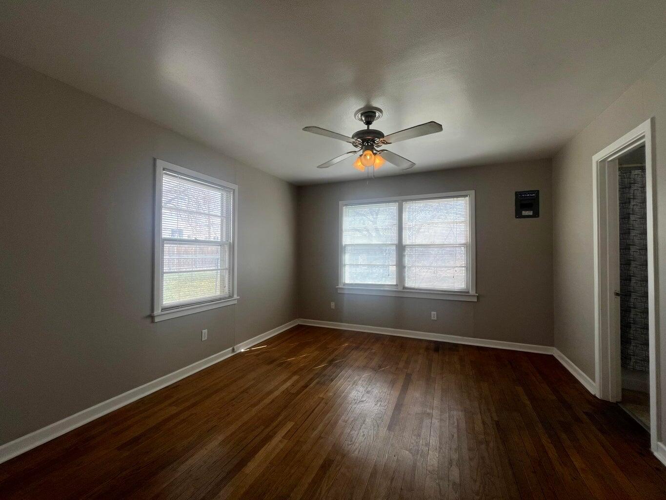 3113 33rd Street, Unit A Lubbock, TX 79410 - Photo 7 of 10 an empty room with wooden floor and windows