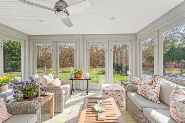 a living room with furniture and floor to ceiling windows