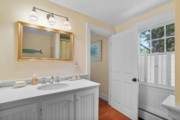a bathroom with a granite countertop sink mirror and a window