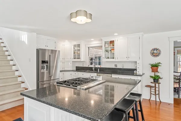 a kitchen with stainless steel appliances granite countertop a stove refrigerator sink and cabinets