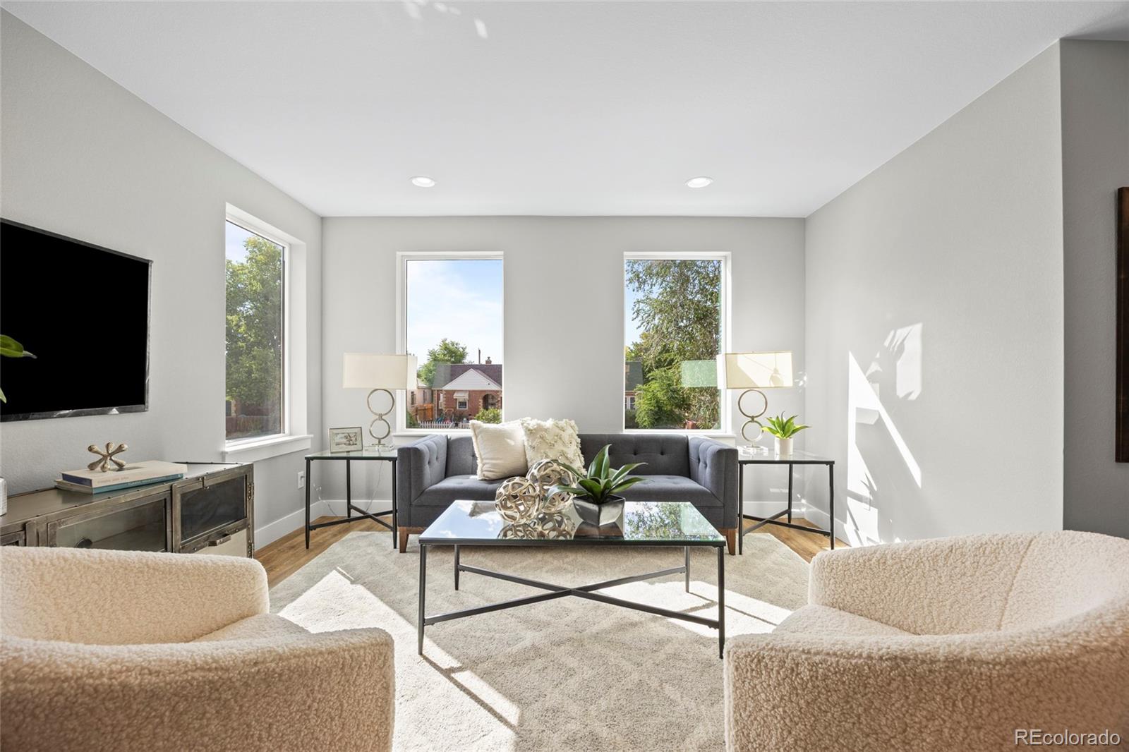 3420 Steele Street Denver, CO 80205 - Photo 19 of 50 a living room with furniture and a flat screen tv