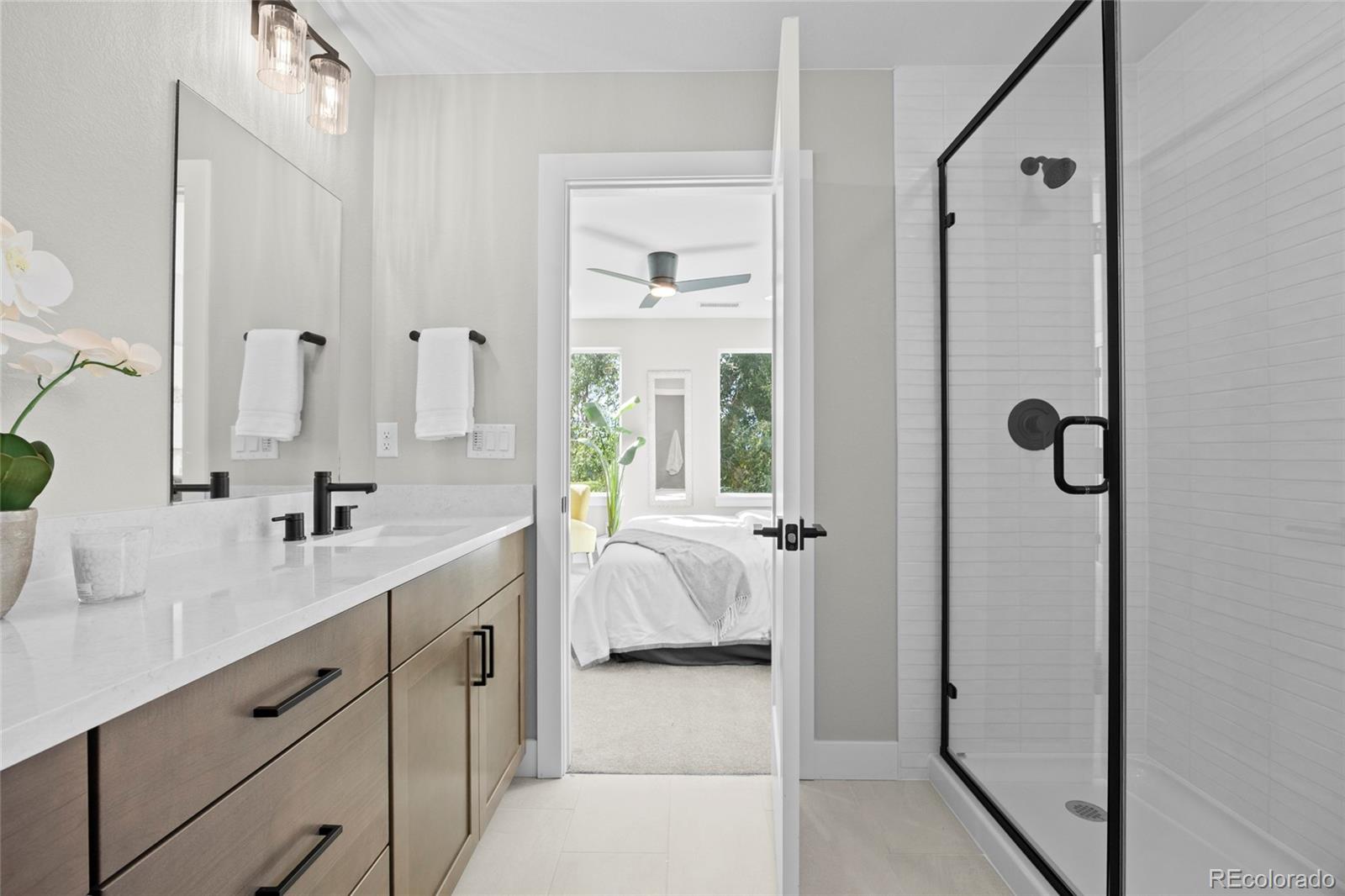 3420 Steele Street Denver, CO 80205 - Photo 26 of 50 a en suite bathroom with a double vanity sink a mirror and shower