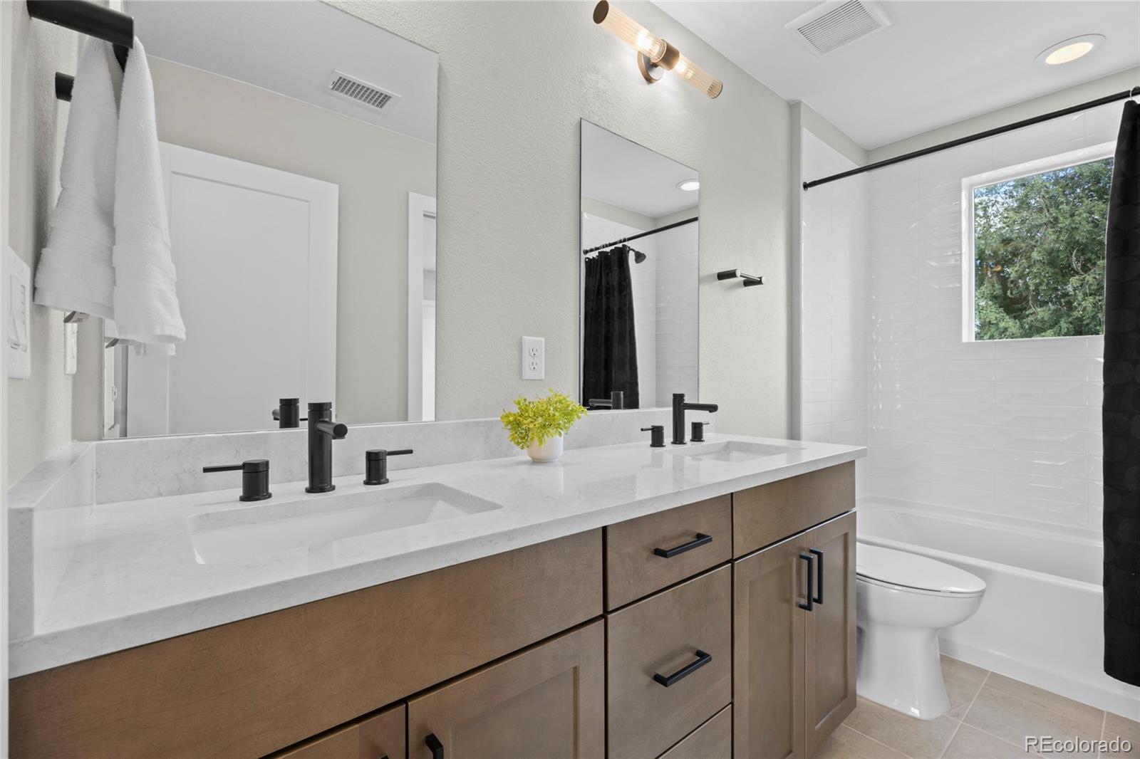 3420 Steele Street Denver, CO 80205 - Photo 30 of 50 a bathroom with a double vanity sink toilet and mirror
