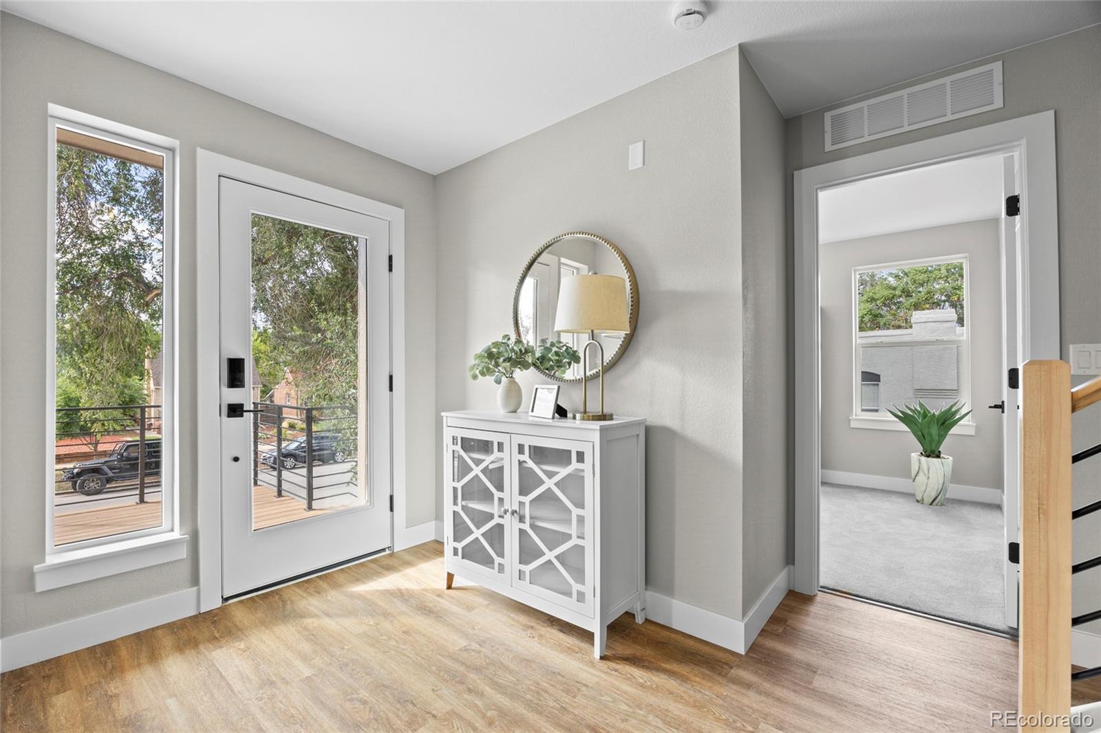 3420 Steele Street Denver, CO 80205 - Photo 8 of 50 a view of a livingroom with furniture wooden floor mirror and windows
