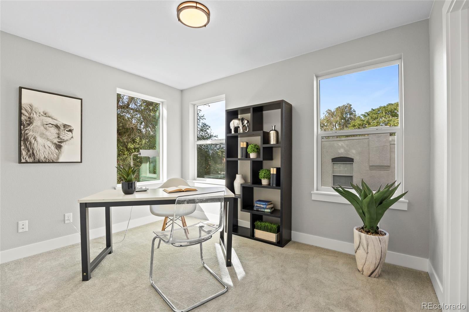 3420 Steele Street Denver, CO 80205 - Photo 9 of 50 a view of a workspace room with furniture and a potted plant