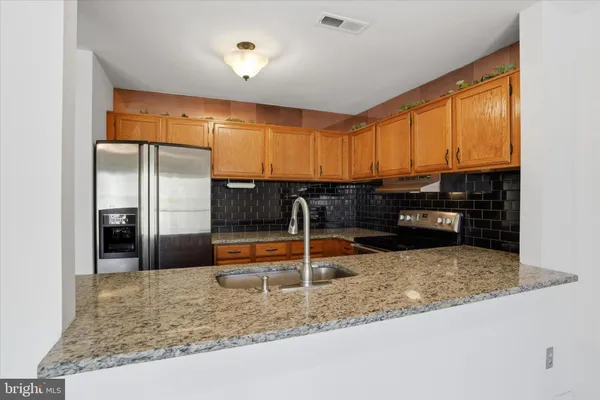 a kitchen with stainless steel appliances granite countertop a sink refrigerator and microwave