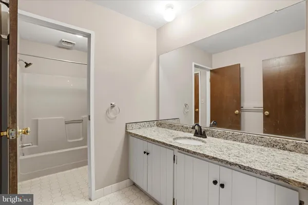 a bathroom with a granite countertop sink and a mirror