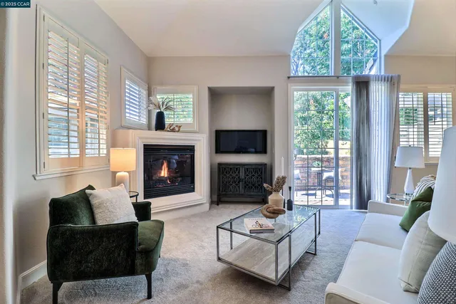 a living room with furniture a large window and a fireplace
