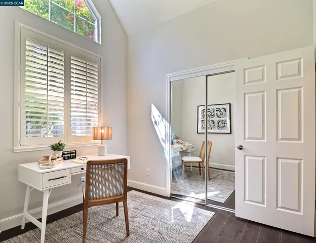 a view of a workspace with furniture and a window