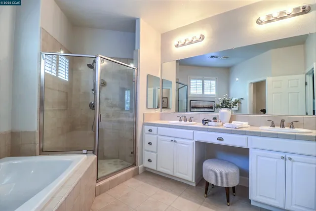 a spacious bathroom with a double vanity sink toilet mirror and bathtub