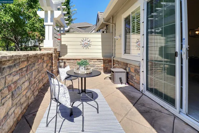 a patio with table and chairs and potted plants