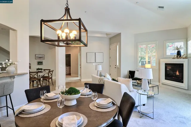 a dining room with furniture a chandelier and wooden floor