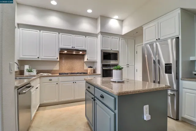 a kitchen with stainless steel appliances granite countertop a refrigerator sink and cabinets