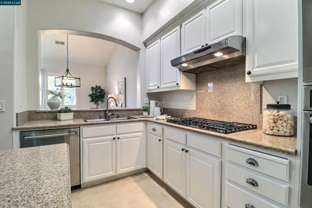 a kitchen with stainless steel appliances granite countertop a sink and cabinets
