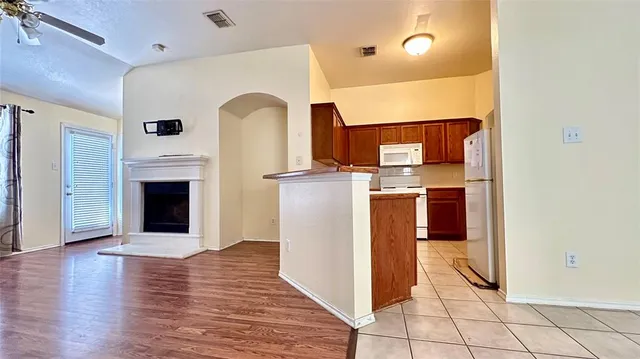 a view of a kitchen with wooden floor and fireplace