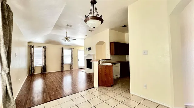 a view of a house with a yard plants and large tree