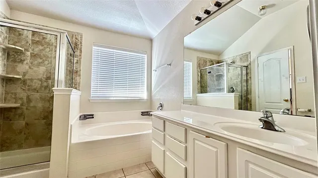 a bathroom with a granite countertop sink a mirror and a bathtub