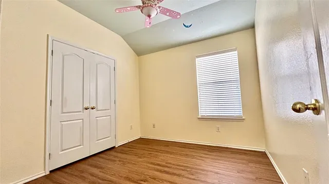 an empty room with wooden floor and entrance
