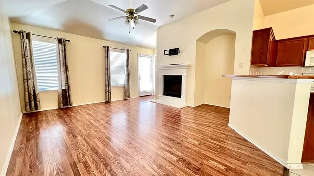 a view of a kitchen with wooden floor and a ceiling fan