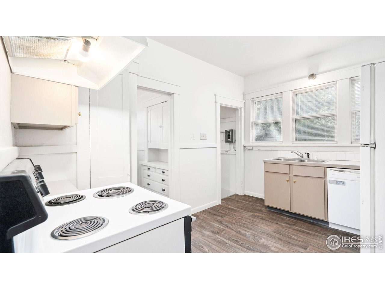 1029 Cranford Place Greeley, CO 80631 - Photo 11 of 34 a kitchen with a sink a stove a refrigerator and white cabinets
