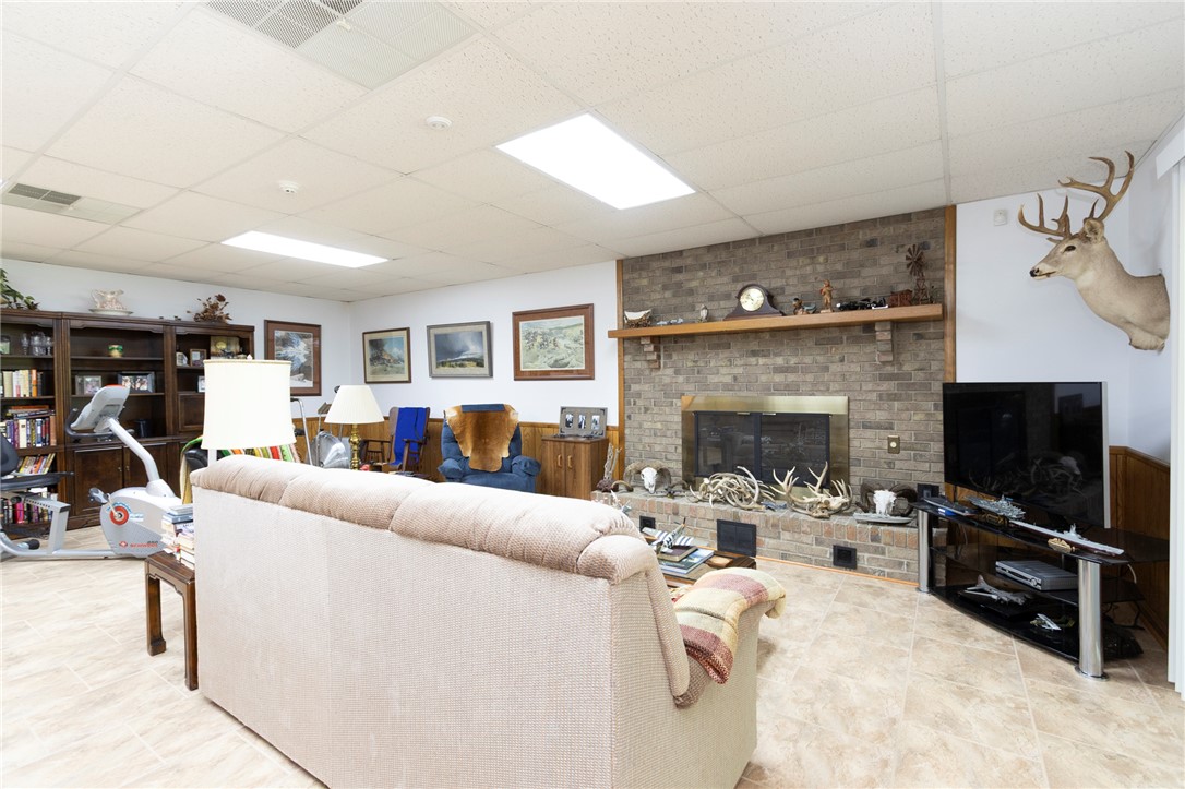 202 Plantation Point Anderson, SC 29625 - Photo 32 of 48 A well-lit basement living area offers a cozy fireplace with a mantle for displays.