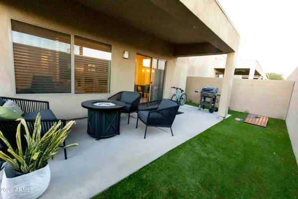 a living room with patio furniture and a potted plant