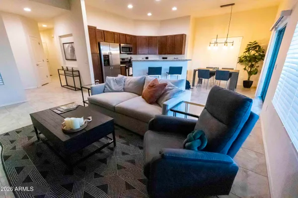 a living room with furniture and a view of kitchen