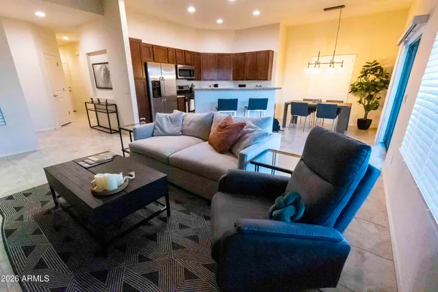 a living room with furniture and a view of kitchen
