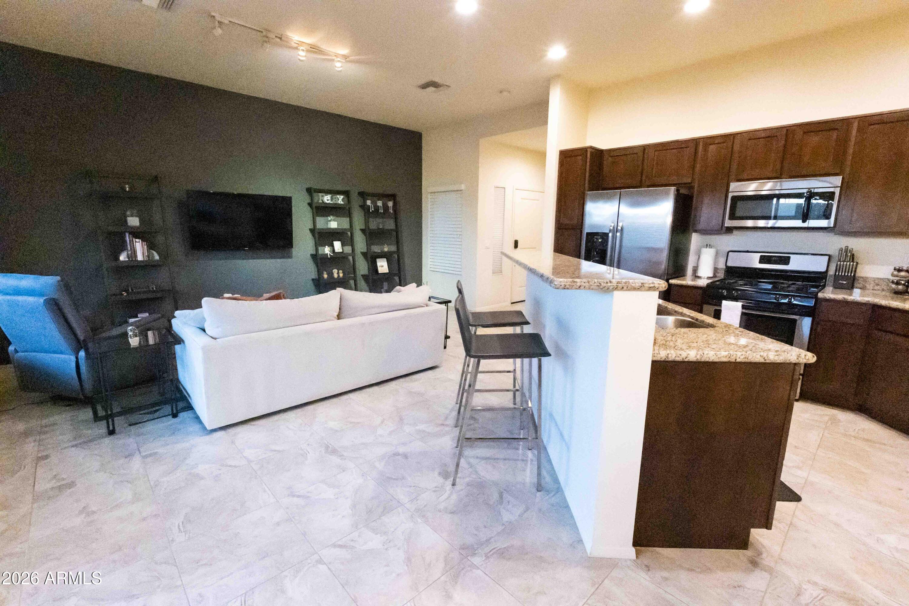 3113 East Danbury Road, Unit 22 Phoenix, AZ 85032 - Photo 6 of 17 a living room with furniture a flat screen tv and a fireplace