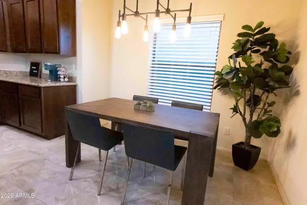 a room with a table chairs and a potted plant