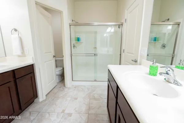 a bathroom with a granite countertop sink a mirror and a shower