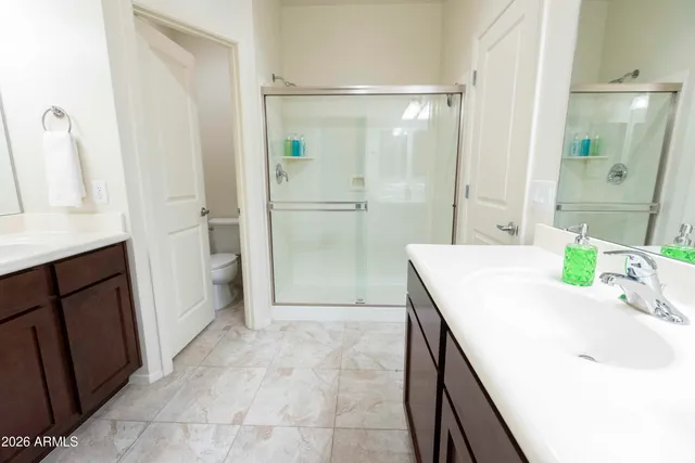 a bathroom with a granite countertop sink a mirror and a shower