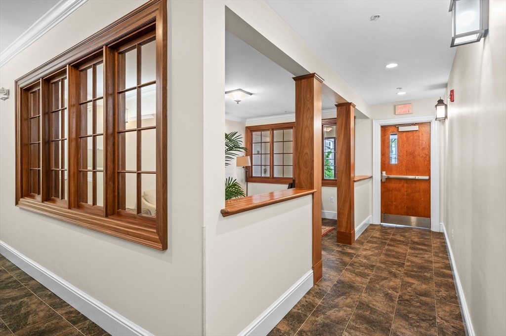 33 Intrepid Circle, Unit 405 Marblehead, MA 01945 - Photo 30 of 31 a view of a hallway with wooden floor and a kitchen