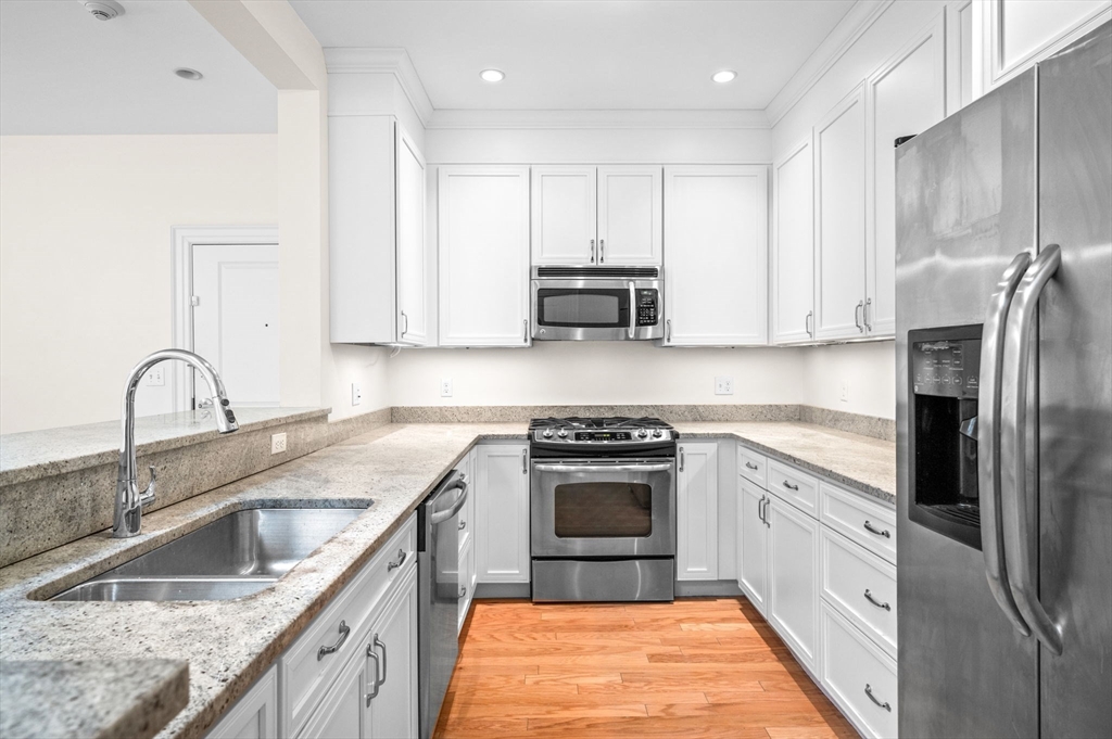33 Intrepid Circle, Unit 405 Marblehead, MA 01945 - Photo 5 of 31 a kitchen with stainless steel appliances granite countertop a sink stove and refrigerator