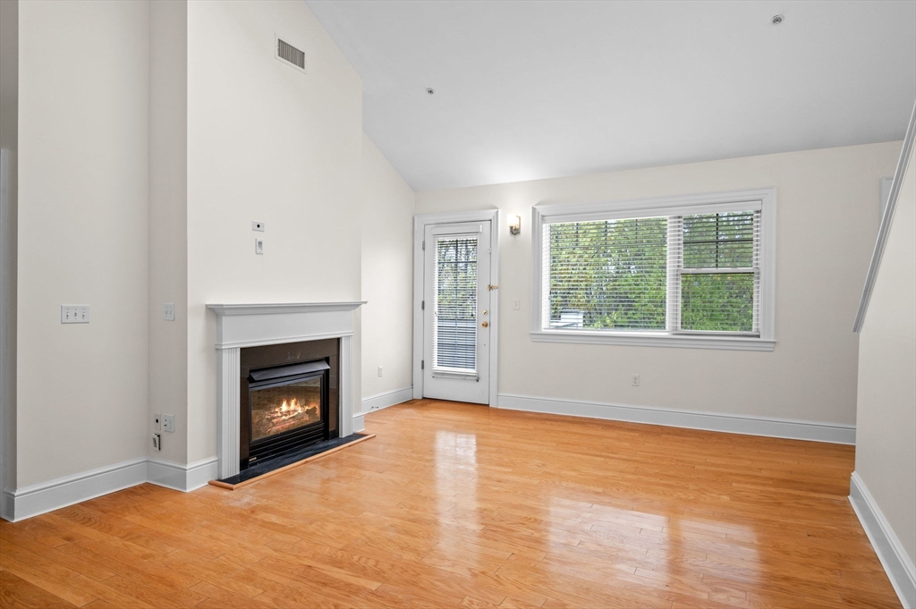 33 Intrepid Circle, Unit 405 Marblehead, MA 01945 - Photo 9 of 31 a view of empty room with wooden floor and fireplace